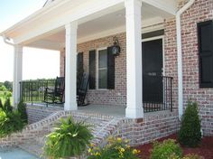 a brick house with white pillars and black shutters