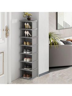 a shoe rack in the corner of a room next to a couch and potted plant