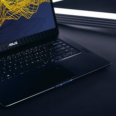 an open laptop computer sitting on top of a black table next to a window with yellow lines