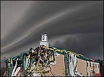 an image of a building that is covered in cloths and other things under a cloudy sky