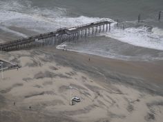 an aerial view of the beach and pier