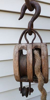 a piece of metal hanging from a hook on a house's exterior wall with rope attached to it