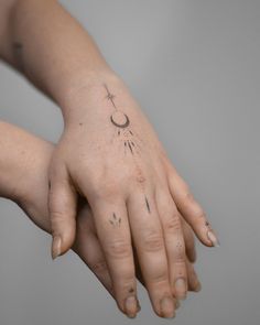 a woman's hand with a tattoo on it and a cross in the middle