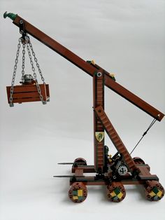 a lego crane is shown with wheels and chains on it's back end, as if to pull something off the ground