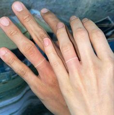 two hands are touching each other with their fingers