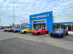 several cars parked in front of a chevrolet dealership