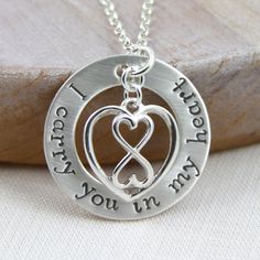 a silver necklace with two hearts and the words i love you in cursive writing