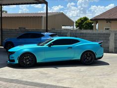 two blue cars parked next to each other