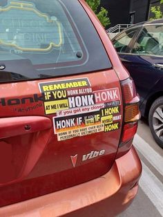 a red van with stickers on it parked in a parking lot next to other cars