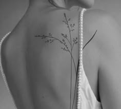 the back of a woman's shoulder with flowers and pearls on her left side