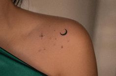 a woman's shoulder with a crescent and stars tattoo on it