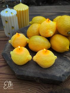 some lemons are sitting on a table with candles