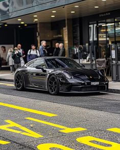 a black sports car is parked on the street