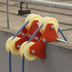 three yellow wheels attached to a concrete wall