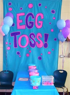 an egg toss table with blue and pink decorations