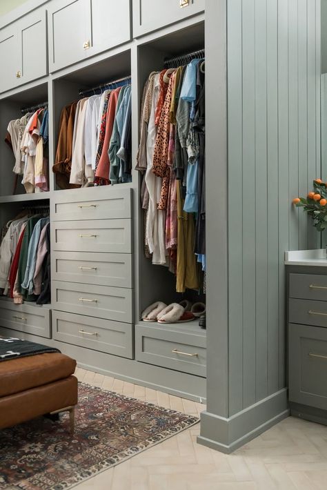 Large closet with hers side with built in shelving, drawers, and racks. Brown leather ottoman with moody warm toned rug. Finished Closet Ideas, Tile In Closet, Custom Closet Color Ideas, Dresser In Master Closet, White Custom Closet, Closet Colors Paint Walk In, Small Closet With Window, Painted Walk In Closet, Closet To Built In