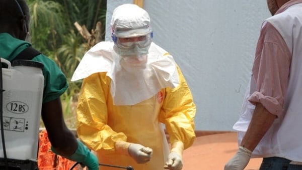 A medical staff worker disinfects his gloves at a centre for victims of the Ebola virus in Gueckedou, Guinea