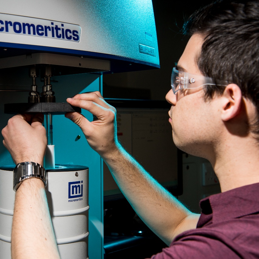 Research student working at a piece of precision equipment