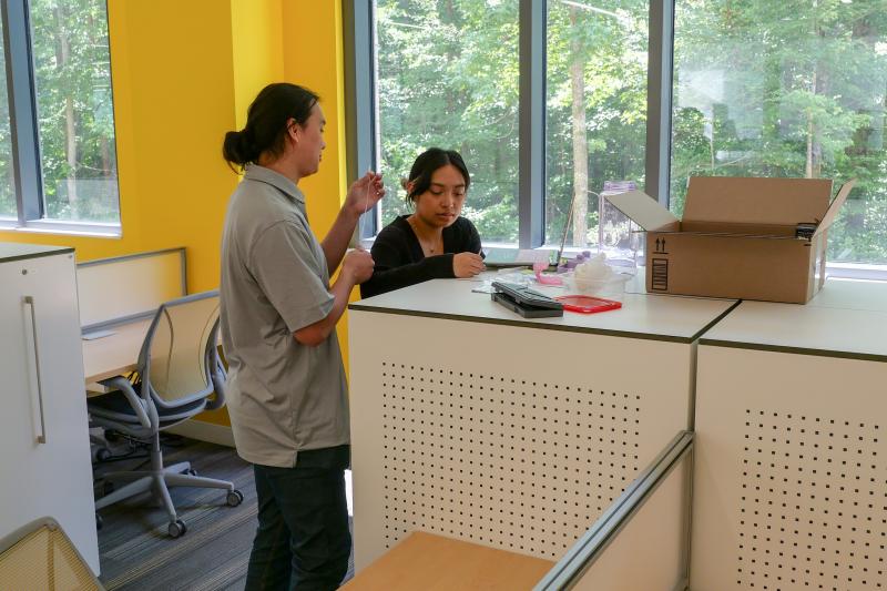 Two students work with microelectronics at desk