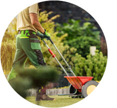 Lawn care pro fertilizing a home lawn