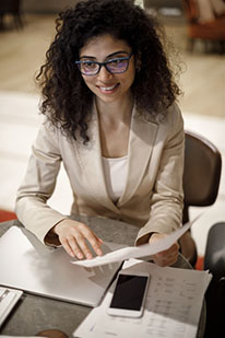 woman in suit sitting at a table holding papers