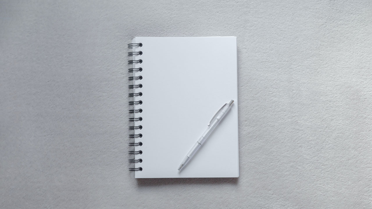 Open notepad with pen lying on top