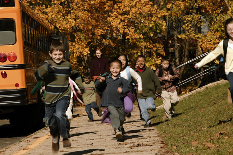 A group of students running out of a school bus