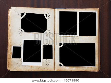 Vintage photo album with blanked photos on old wooden texture