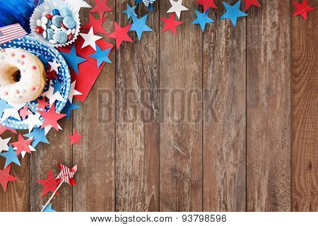 american independence day, celebration, patriotism and holidays concept - close up of glazed donut with candies in disposable tableware and stars at 4th july party from top over wooden background