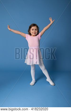 Full Length Portrait Of A Beautiful Child Ballerina Performing Ballet Dancing Isolated On Blue Backg