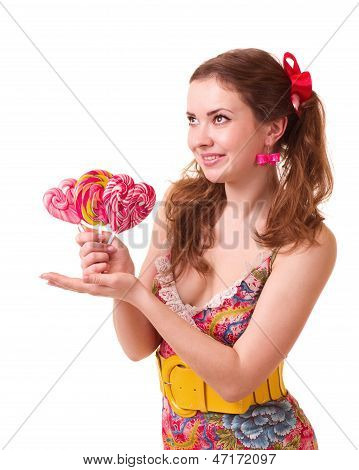 Beautiful young girl with pink spiral lollipops on white background.