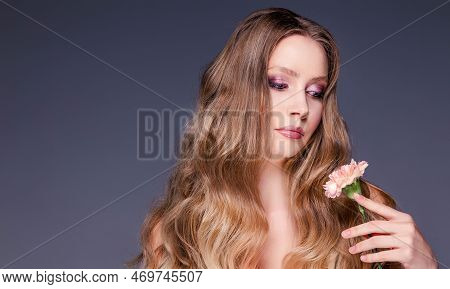 Beauty Portrait Of A Girl. Beautiful Woman Posing With Carnation Flower. Facial Treatments. Cosmetol